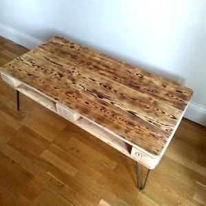 Charred wood upcycled coffee table in rustic, farmhouse pallet style made of salvaged wood with industrial hairpin legs