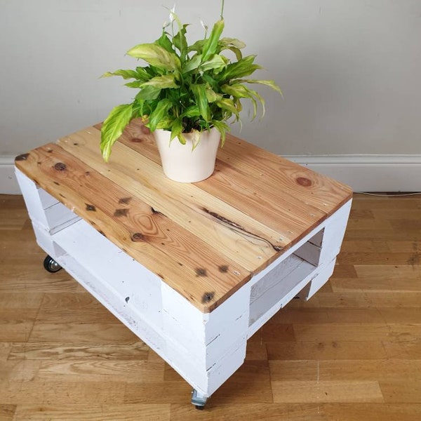 Shabby chic reclaimed wood pallet coffee table finished in a distressed white finish with industrial style castor wheels