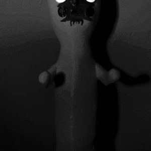 Puede incluir: Una ilustraci&oacute;n en blanco y negro de una criatura con cabeza puntiaguda, ojos grandes y una sonrisa de dientes. La criatura est&aacute; de pie con los brazos extendidos.