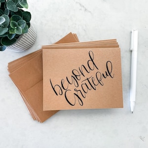May include: A stack of brown kraft paper cards with the text "beyond grateful" written in black calligraphy.