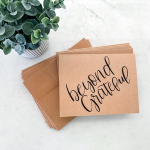 May include: A stack of brown kraft paper cards with the text "beyond grateful" written in black calligraphy.