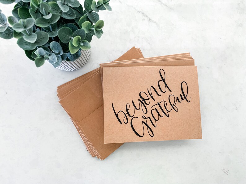 May include: A stack of brown kraft paper cards with the text "beyond grateful" written in black calligraphy.