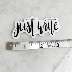 May include: A white sticker with black calligraphy that reads "just write". The sticker is measured against a white ruler that shows 3 inches.