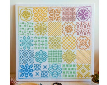 Puede incluir: Un patrón de punto de cruz colorido en un lienzo blanco. El patrón está formado por 25 cuadrados, cada uno con un diseño diferente. Los cuadrados están dispuestos en una cuadrícula, y los colores de los cuadrados cambian gradualmente de morado a verde.