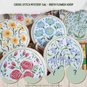 Könnte beinhalten: Mehrere runde Stickrahmen aus Holz mit Kreuzstichmustern verschiedener Geburtsblumen, darunter gelbe Narzissen, blaue Gänseblümchen, rosa Rosen und violette glockenförmige Blumen, sowie zwei leere Rahmen mit Fragezeichen.