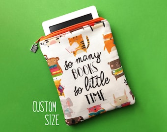 Könnte beinhalten: Eine Tablet-Hülle aus weißem Stoff mit buntem Tierdruck und dem Text "so many BOOKS so little TIME". Die Hülle hat einen orangefarbenen Reißverschluss und einen silbernen Reißverschluss. Die Worte "CUSTOM SIZE" sind ebenfalls aufgedruckt.