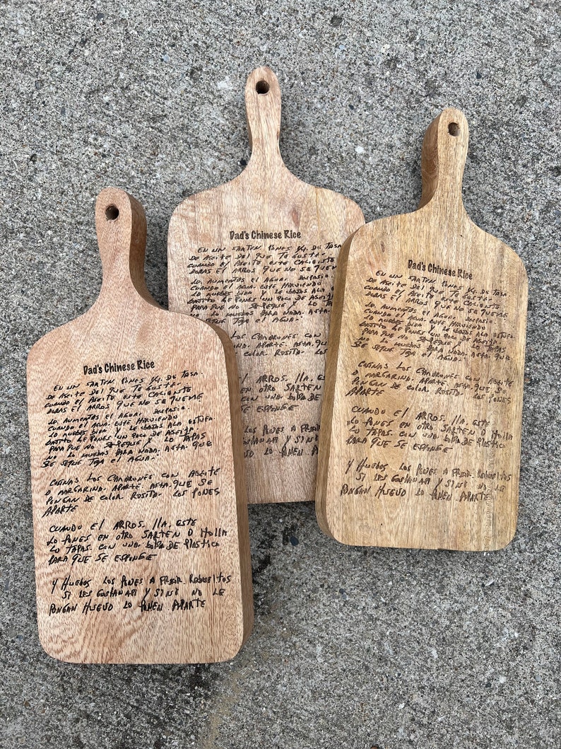 K&ouml;nnte beinhalten: Drei Holzschneidebretter mit handgeschriebenen Anweisungen zum Kochen von chinesischem Reis. Die Anweisungen sind in Kursivschrift geschrieben und beinhalten Details zu Garzeiten, Zutaten und der Zubereitung des Reises.