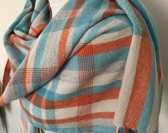A soft handwoven lambswool scarf accented  orange and blue