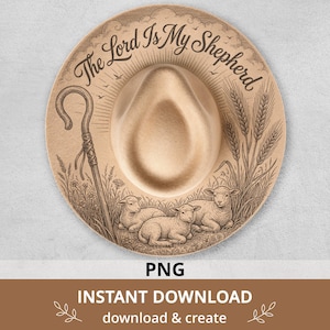 May include: A tan felt hat featuring a dark brown engraved illustration of a shepherd's crook, wheat stalks, and three resting lambs. The text "The Lord Is My Shepherd" is arched across the top in a decorative script font above the crown.