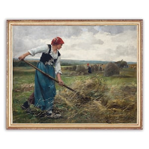 May include: Framed oil painting depicting a woman in a red headscarf and blue skirt raking hay in a field. Other figures are seen in the background, working with hay bales. The artwork is set in a gold-colored frame.