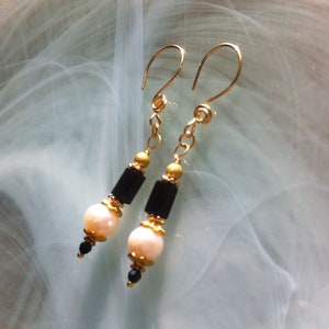 Unique earrings composed of freshwater pearls surrounded by gold-plated cups, tiny spinels and black Jet tubes of Swarovski crystal