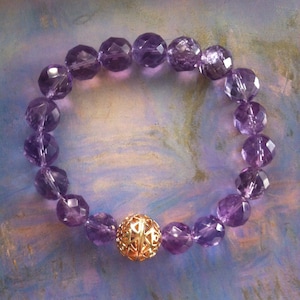 Stretch bracelet composed of limpid quality Amethysts and a central decorative pearl in filigreee gold plated