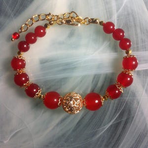 Bracelet with a central gold-plated filigree bead surrounded by smooth Quartz beads, flowered cups and faceted gold-plated hematite beads