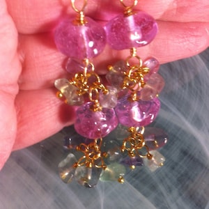 May include: A pair of dangle earrings with pink and green gemstone beads and gold chain links.