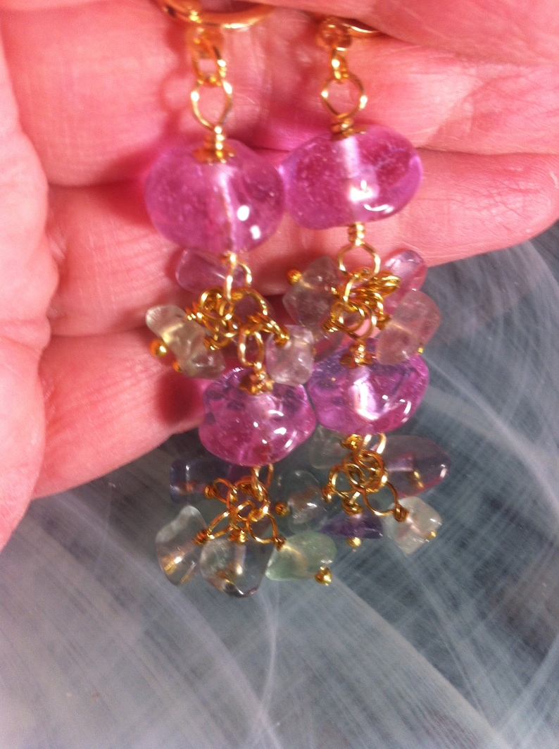 May include: A pair of dangle earrings with pink and green gemstone beads and gold chain links.