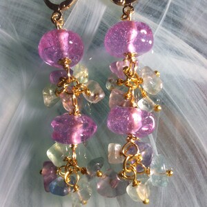 May include: A pair of dangle earrings with pink and green glass beads and gold accents.
