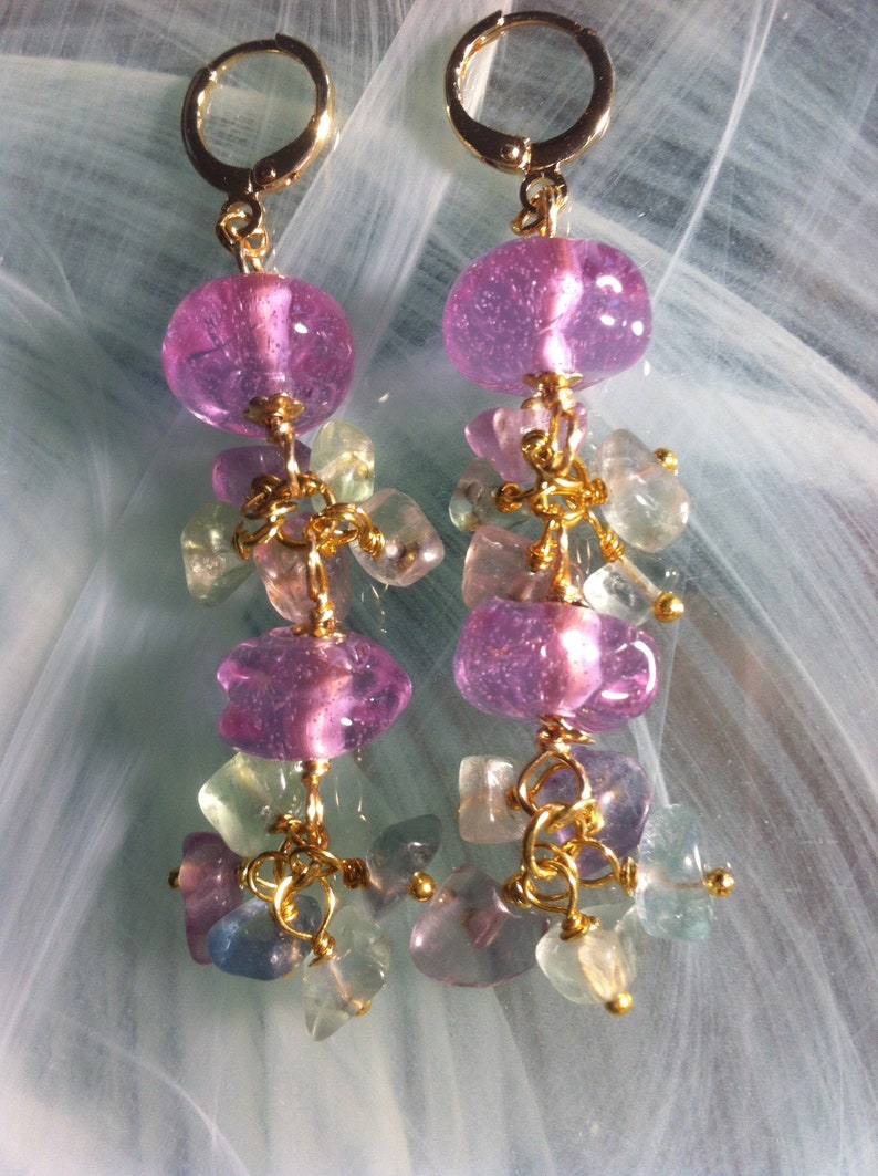 May include: A pair of dangle earrings with pink and green glass beads and gold accents.