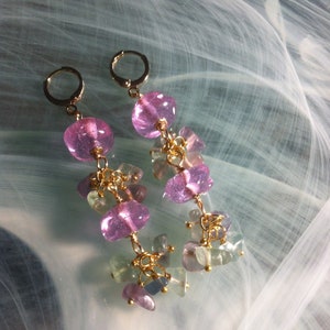 May include: A pair of dangle earrings with pink and green gemstone beads and gold accents.