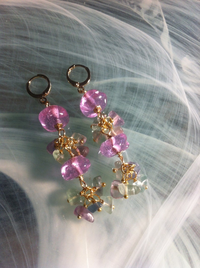 May include: A pair of dangle earrings with pink and green gemstone beads and gold accents.