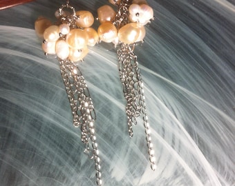 Cascading earrings of white freshwater pearls and pale pink iridescent natural pearls suspended from silver hoops