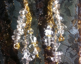 Earrings resembling grand chandeliers, featuring rock crystal nuggets arranged in three tiers on rope chains
