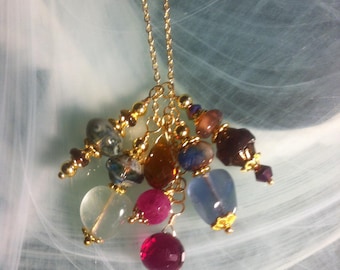 Pendant features irregular beads of Fluorite, the poet's stone, mini brown Tourmaline rondelles, ruby onion and a strawberry Quartz bead