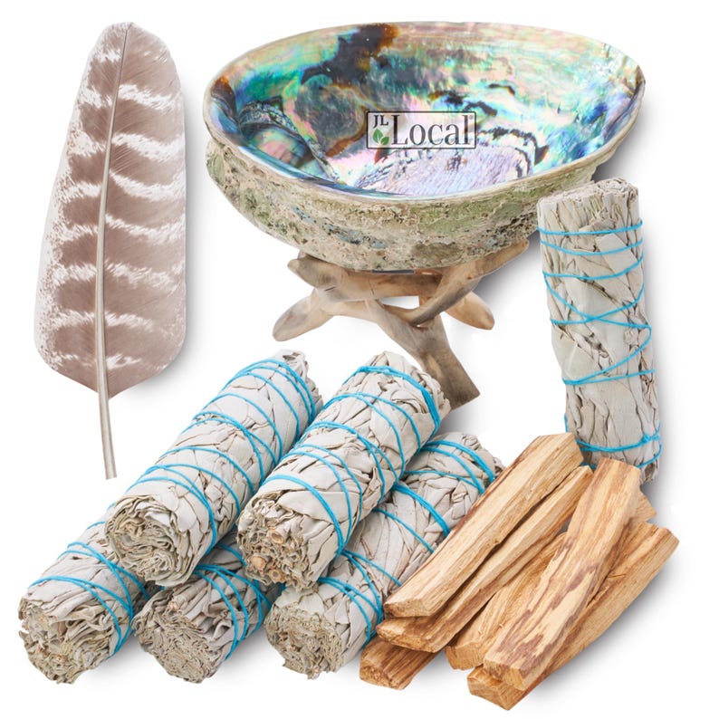 May include: A set of smudging tools including white sage bundles, palo santo sticks, a feather, and an abalone shell with a wooden stand. The abalone shell has an iridescent rainbow sheen.