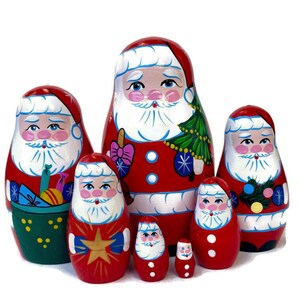 May include: A set of six nesting Santa Claus dolls, also known as Russian nesting dolls or matryoshka dolls. The dolls are painted in traditional red and white colours with festive details like presents, a Christmas tree, and snowflakes. The largest doll is about 10 inches tall and the smallest is about 2 inches tall.