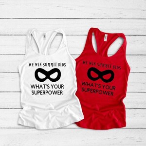 May include: Two tank tops with the text "We win summit bids" and a superhero mask graphic. The text "What's your superpower?" is below the graphic. One tank top is white and the other is red.