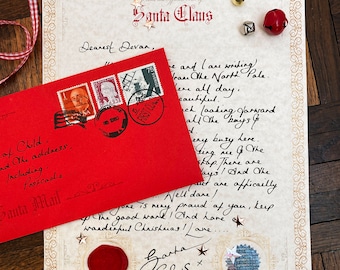 Può includere: Una lettera scritta a mano da Babbo Natale su carta color crema con una busta rossa e francobolli. La lettera è indirizzata a Devan e include il testo "From the Official Desk of Santa Claus".