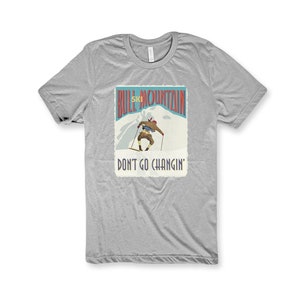 K&ouml;nnte beinhalten: Graues T-Shirt mit einer Grafik im Vintage-Stil eines Skifahrers auf einem Berg. Die Grafik lautet "Bull Mountain Ski" und "Don't Go Changin'."