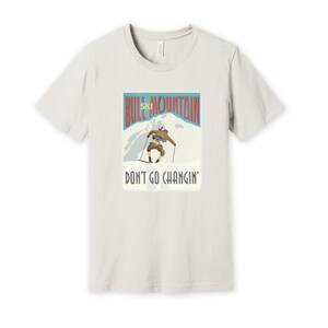 K&ouml;nnte beinhalten: Ein wei&szlig;es T-Shirt mit einer Grafik im Vintage-Stil eines Skifahrers auf einem Berg. Die Grafik lautet "Bull Mountain Ski" und "Don't Go Changin'."