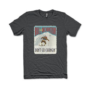 K&ouml;nnte beinhalten: Ein dunkelgraues T-Shirt mit einer Vintage-Illustration eines Skifahrers auf einem Berg. Der Text "Bull Mountain Ski" und "Don't Go Changin'" ist auf dem Shirt aufgedruckt.
