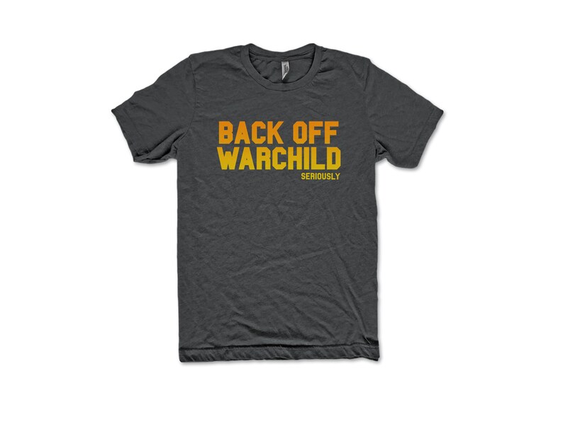May include: A dark gray t-shirt with the text "BACK OFF WARCHILD" in orange and yellow lettering. The text "SERIOUSLY" is printed in smaller letters below the main text.