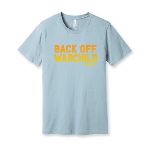 May include: A light blue t-shirt with the text "Back Off Warchild" printed in orange on the front.