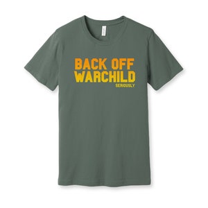 May include: A dark green t-shirt with the text "BACK OFF WARCHILD SERIOUSLY" printed in orange and yellow.