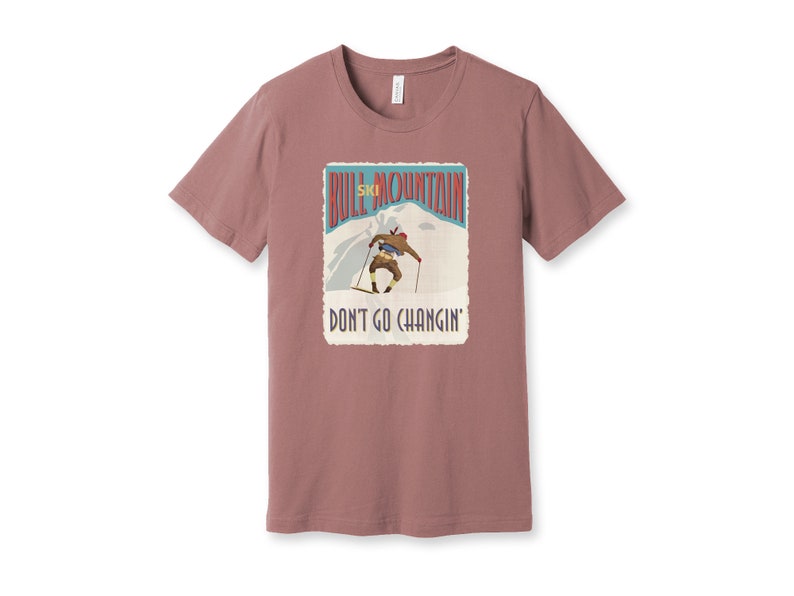 K&ouml;nnte beinhalten: Ein mauvefarbenes T-Shirt mit einer Grafik im Vintage-Stil eines Skifahrers auf einem Berg. Die Grafik lautet "Bull Mountain Ski" und "Don't Go Changin'."