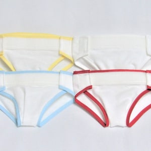 May include: Four pairs of white underwear with different colored trim. The trim colors are yellow, light blue, red, and red.