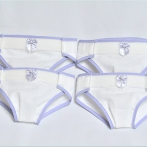 May include: Four white cloth diapers with a light purple trim and a small bow. The diapers are designed with a soft, absorbent material and are suitable for babies. The image shows the diapers neatly arranged.