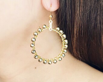 Gold bead wire wrapped hoop earrings.