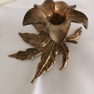 Portavelas, candelabro de latón, delicado y elegante, una flor colocada sobre la hoja, Vintage Europeo