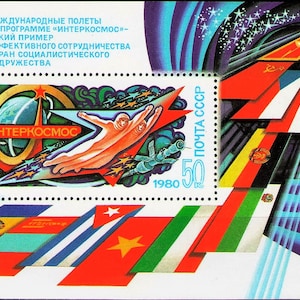 May include: A vintage postage stamp featuring a space theme. The stamp has the text "INTERKOSMOS" and depicts an astronaut, a rocket, and a stylized Earth. The stamp also includes the text "1980" and "ПОЧТА СССР". The background is a mix of red, blue, and white.