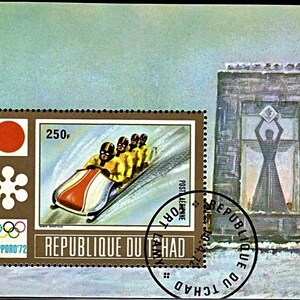 Puede incluir: Un sello marrón y blanco con un círculo rojo y un copo de nieve blanco. El sello presenta un trineo con cuatro atletas corriendo por una pista nevada. El sello también incluye el texto "REPUBLIQUE DU TCHAD" y "SAPPORO '72".