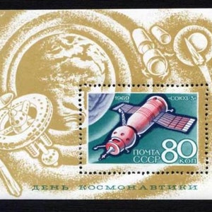 Può includere: Un francobollo sovietico vintage che presenta un'astronave rossa e bianca in orbita attorno a un pianeta blu e bianco. Il francobollo è dorato e presenta il testo "ПОЧТА СССР" e "80 коп" in scrittura cirillica. Il francobollo presenta anche il testo "1969" e "СОЮЗ-3" in scrittura cirillica. Il francobollo è intitolato "ДЕНЬ КОСМОНАВТИКИ" in scrittura cirillica, che si traduce in "Giornata della Cosmonautica".