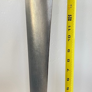 May include: A silver metal propeller blade, approximately 16 inches long, is displayed on a black stand with the text "STRATOFORTRESS" printed on it. A yellow measuring tape is next to the stand.