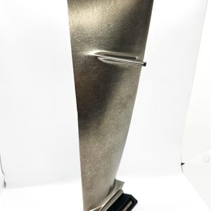 May include: A silver metal model of a jet engine blade on a black base with the text "8-52 STRATOSPHERE" printed on it.