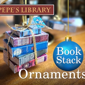 May include: A stack of miniature books tied with gold ribbon and hanging from a blue ornament that reads "Book Stack". The ornament is hanging from a gold string. The books are decorated with colorful covers and titles. The background is a wooden surface with the text "PEPE'S LIBRARY" in a red banner.