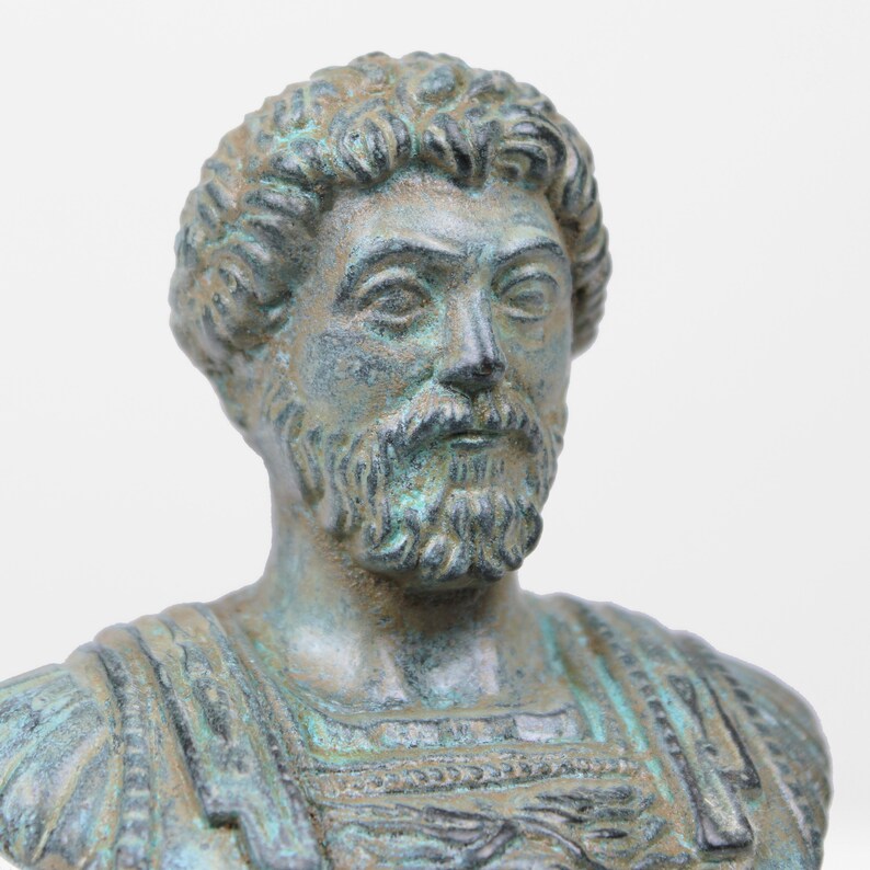 May include: A bronze bust of a man with a beard and short hair. The bust is weathered and has a green patina.