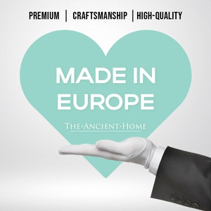 May include: A white gloved hand holding a teal heart with the text "MADE IN EUROPE" and the words "THE ANCIENT HOME" below.