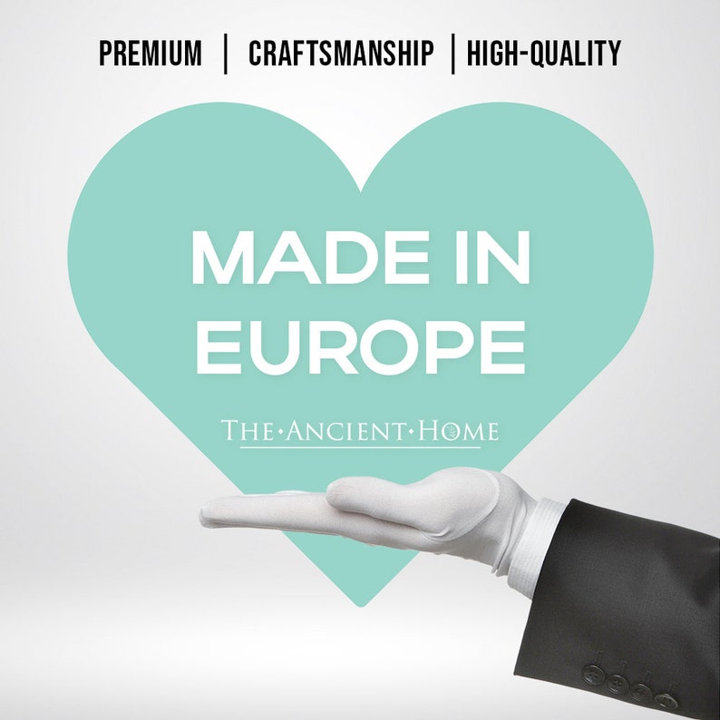 May include: A white gloved hand holding a teal heart with the text "MADE IN EUROPE" and the words "THE ANCIENT HOME" below.